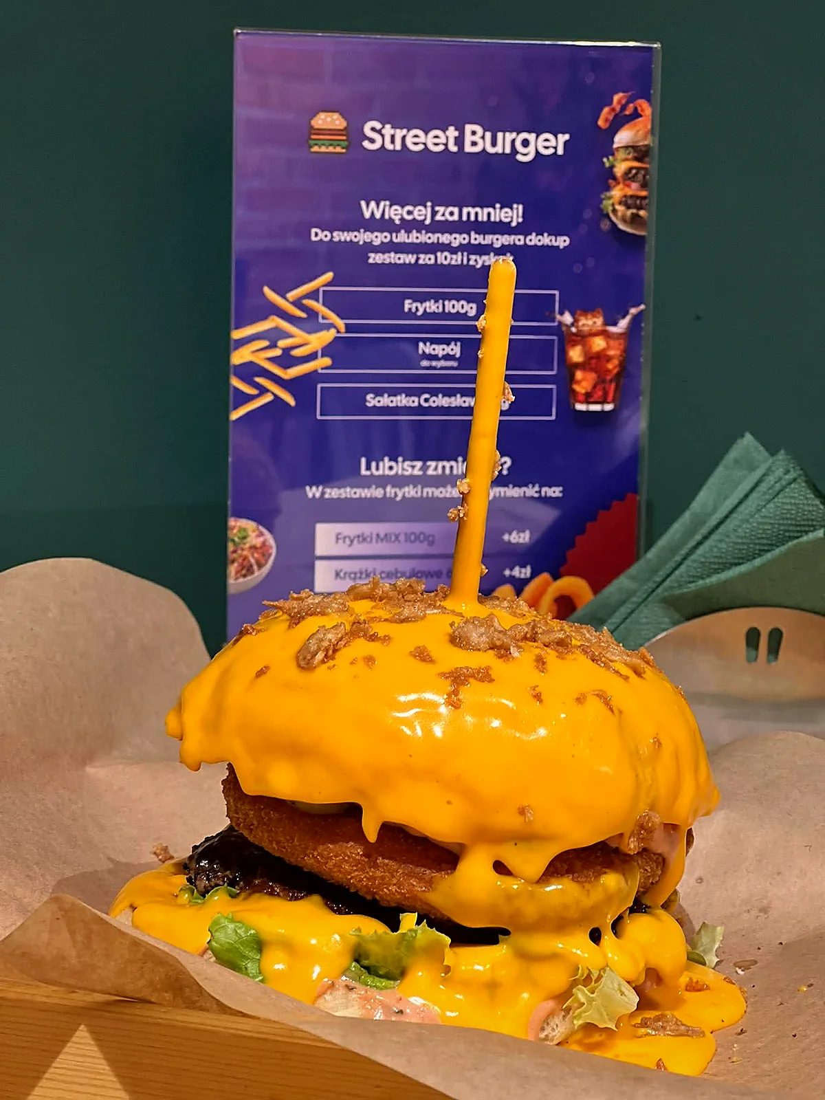 Serowy burger StreetBurger.pl na tle menu
